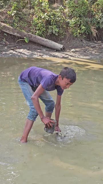 Village Boy fish catching by his hand