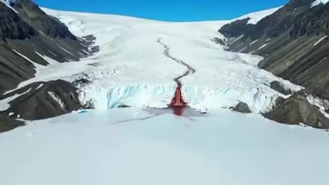 Deep in Antarctica a five-story waterfall pours a red liquid into the white void.