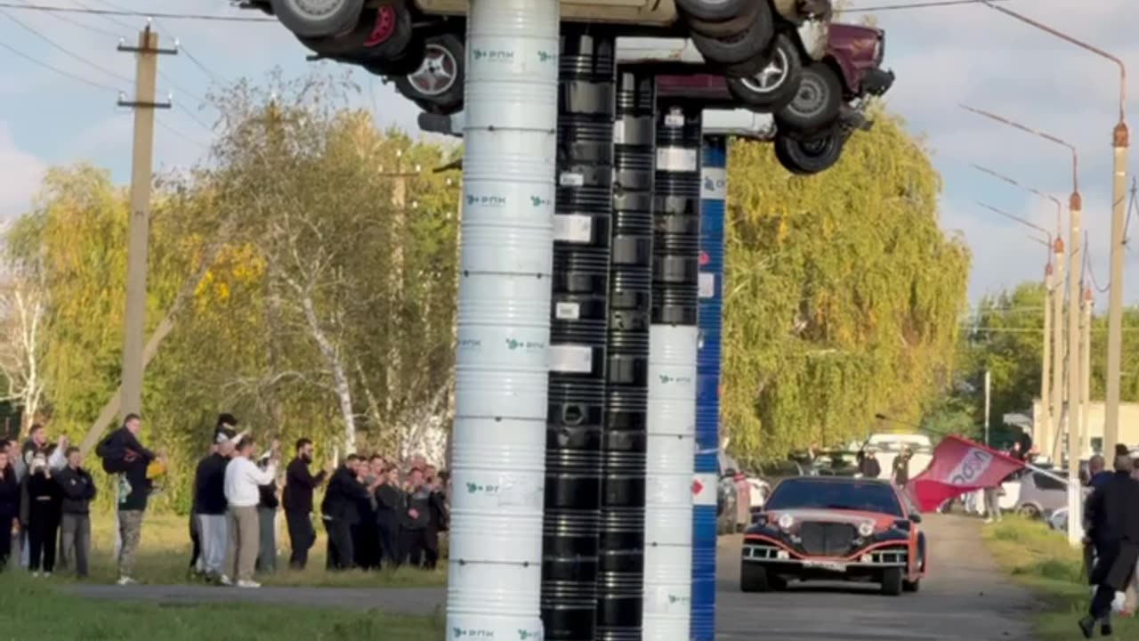 Old Limousine Rams Stacked Barrels With Vintage Soviet Cars on Top