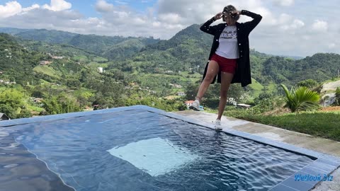 Wetlook girl in pool with mountains in the background