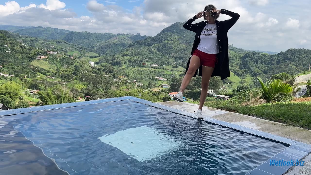 Wetlook girl in pool with mountains in the background
