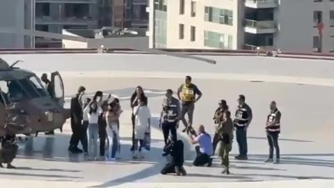 Matan Tsengauker waves from the roof of Ichilov to activists standing on a nearby building