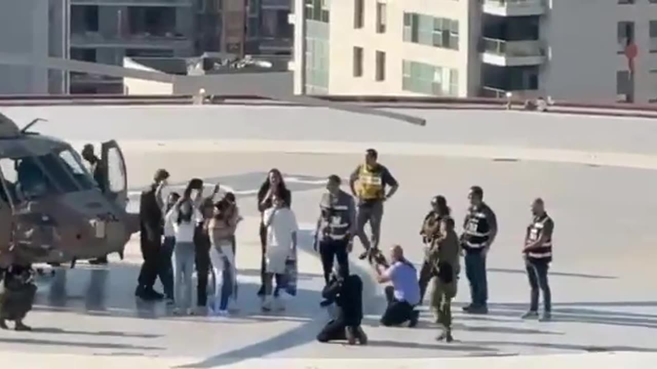 Matan Tsengauker waves from the roof of Ichilov to activists standing on a nearby building