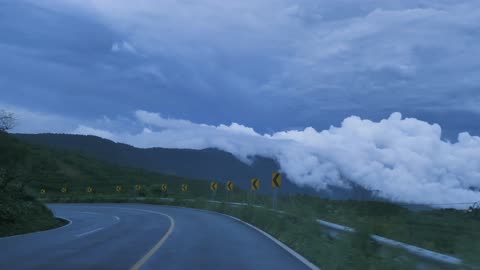 Going down a curved highway through a mountain range