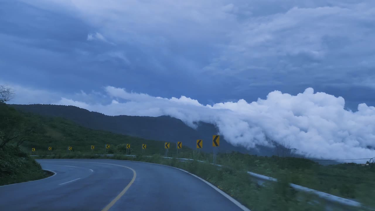Going down a curved highway through a mountain range