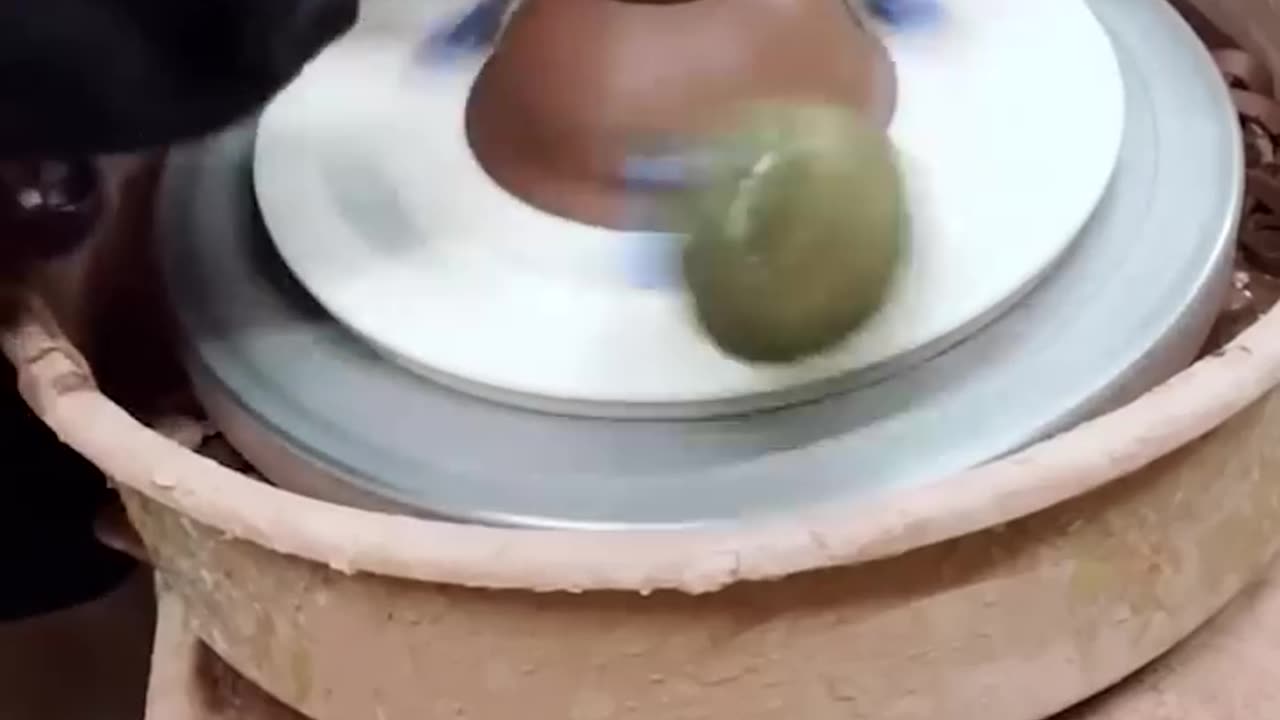 German Shepherd Plays With Tennis Ball on Pottery Wheel