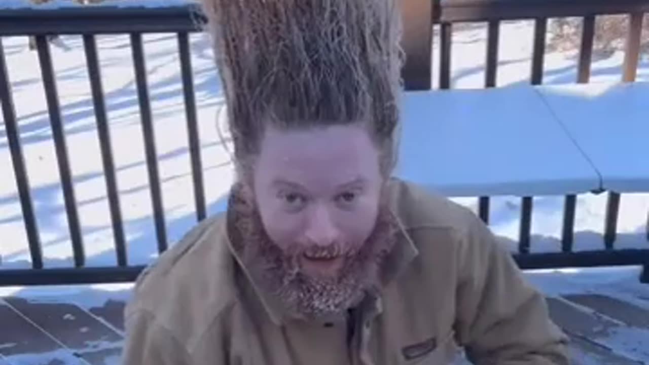Guy freezes his hair and it stands tall.
