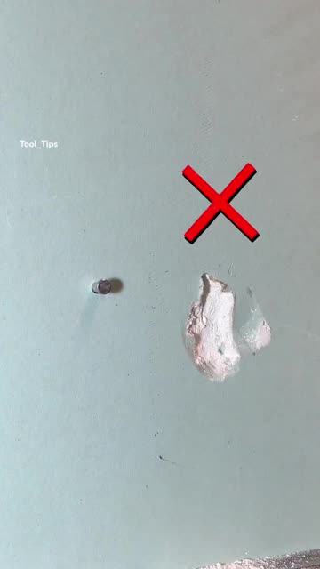 Two Metal Pins Driven Into a Light Gray Wall