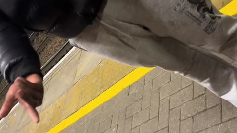 A woman is sat at a train station in London