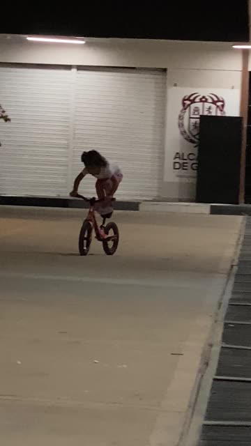 BMX Girl Stands On Bicycle Seat
