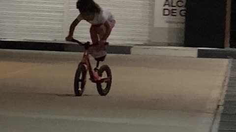 BMX Girl Stands On Bicycle Seat