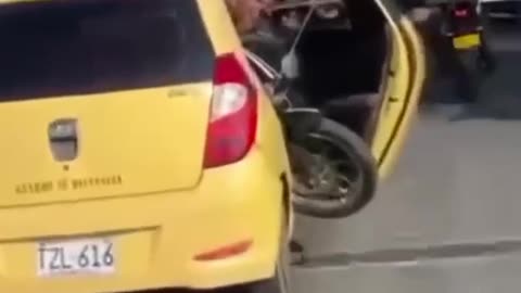 ¡Manda cáscara! Taxi transporta motocicleta con la puerta abierta en puente de la Cordialidad