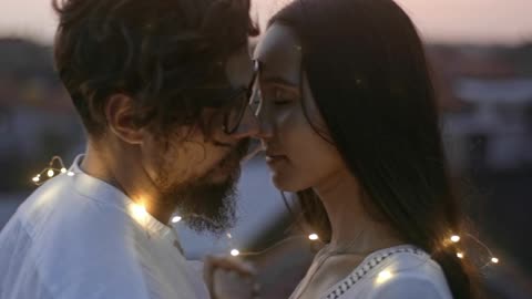 Couple kissing with lighs around