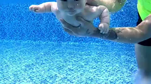 "Father Helps His Baby Take the First Dip and Learn to Swim!"