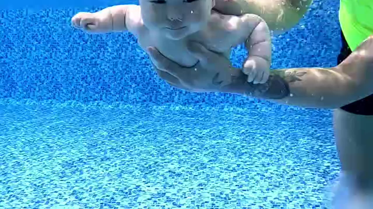 "Father Helps His Baby Take the First Dip and Learn to Swim!"