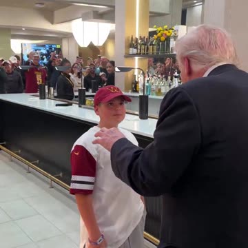 President Trump hands a young boy his presidential challenge coin while leaving the Commanders game