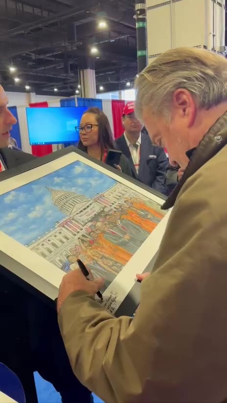 Steve Bannon signs J6 pic “Fellow Inmate”