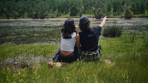 Romantic couple sitting on the shore of a lake