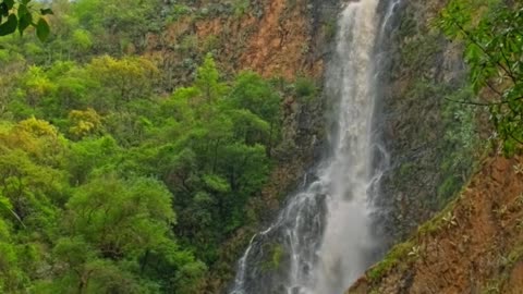 Waterfall amidst lush green hills