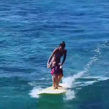 Mother teaches her daughter to surf