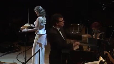 A woman plays a theremin, played only with ENERGY of the hands in this orchestra