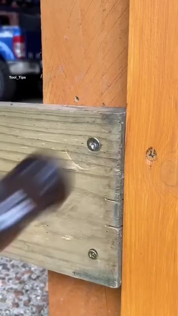 Electric Drill Driving a Screw into a Wood Plank