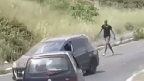 A fake African asylum seeker in Rome throws stones on other people's cars to show who's boss.