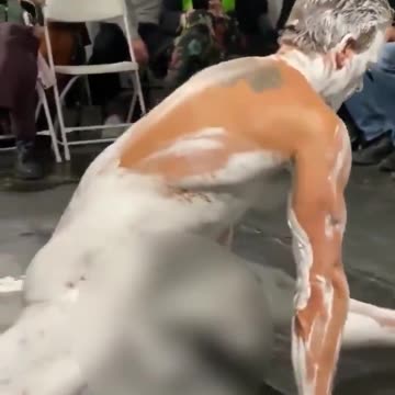 DEVELOPING GRAPHIC: A naked man "wearing" only white paint at an art show