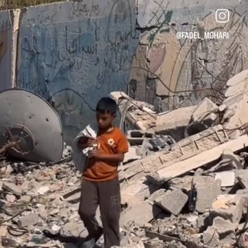 A boy walks through the rubble, carrying a worn-out bag on his shoulder to gather scraps of firewood