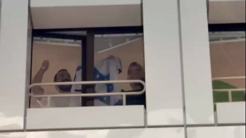 Released hostage waves a flag to the celebrating crowd outside his room at the Safra Hospital.