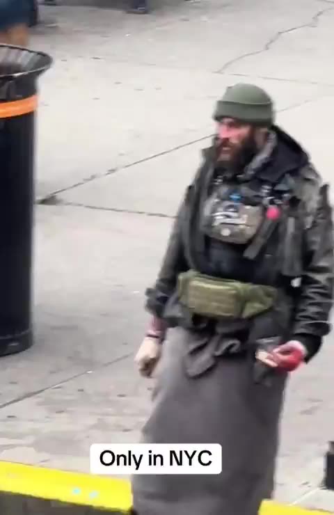 People stroll past this wild-looking man brandishing a knife as if it’s completely normal.