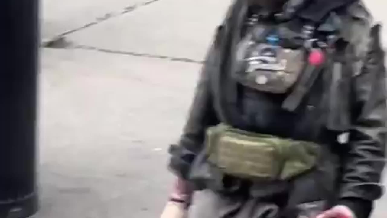 People stroll past this wild-looking man brandishing a knife as if it’s completely normal.