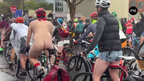 A large group of nude cyclists arrive outside the ICE facility in Portland