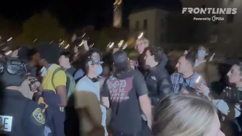 UC BERKELEY- A woman holds her two daughters as she tries to rush them through the screaming