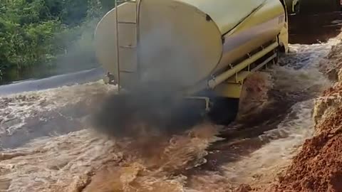 Even though the flood was blocking it, the tanker truck driver continued to pass