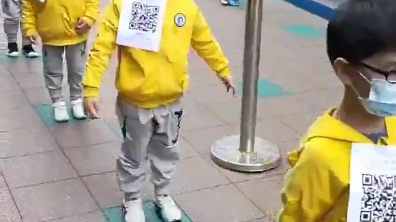 Chinese Children lining up for State Mandated vax, with QR Code for their Vax Passport