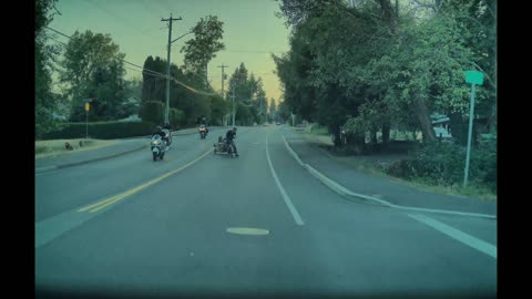 Elderly Bicyclist Pulling Cart Pushed by Passing Motorcyclist