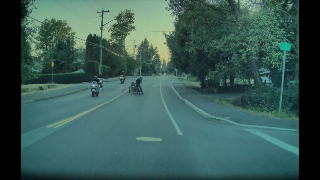 Elderly Bicyclist Pulling Cart Pushed by Passing Motorcyclist