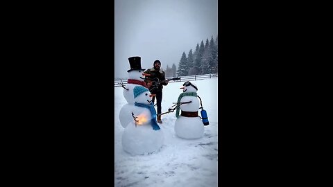 Snowman using a flamethrower to melt 2 snowmen while Joseph Martelli sings