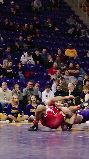 Cheerleaders watch men’s wrestling match up close