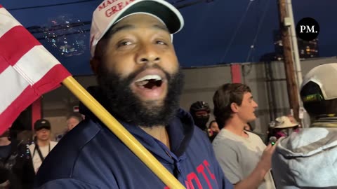 A brave patriot wearing a MAGA hat and carrying an American flag has arrived...