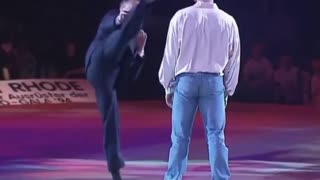 Jean-Claude Van Damme demonstrates his signature kicks in a suit, 1994