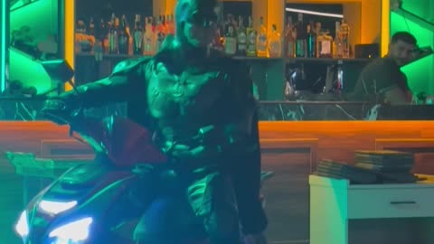 Transformer Dances While Batman Drives a Moped Inside a Bar