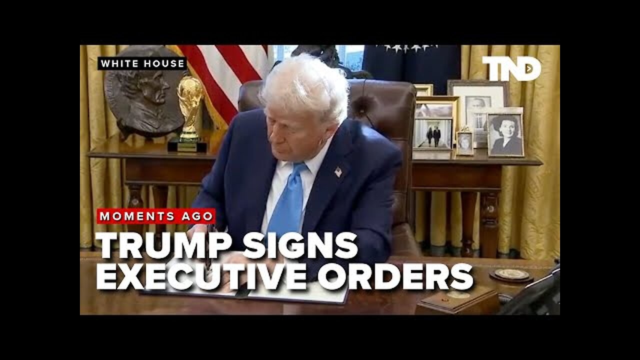President Donald Trump signs executive orders with gaggle of reporters in Oval Office