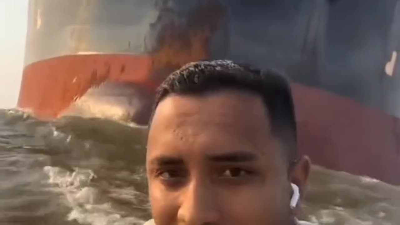 This guy is infront of giant oil tanker ship