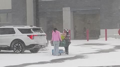 Kind Girl Helps Stranger Push Shopping Cart Through Snowstorm