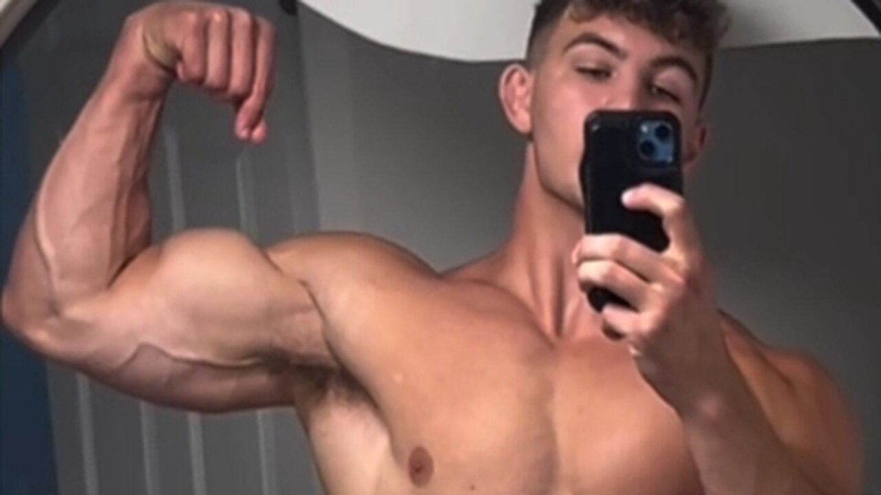 Young aesthetic bodybuilder flexing muscles