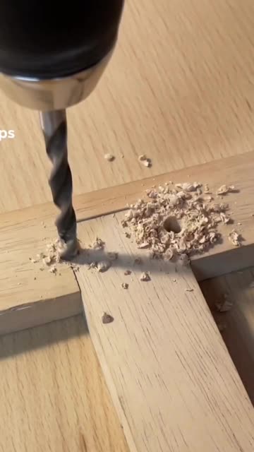 Close-up View of Electric Drill Boring Hole in Wood Board