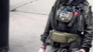 People stroll past this wild-looking man brandishing a knife as if it’s completely normal.