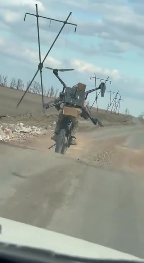 Russian Soldier Rides Motorcycle with Captured Ukrainian Quadcopter — One Prop Still Spinning 😂